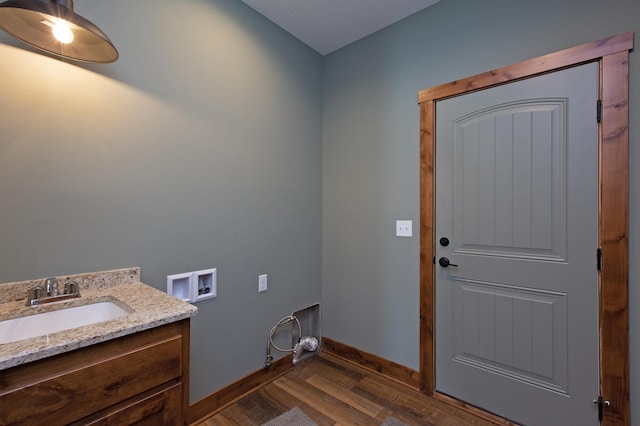 laundry area featuring washer hookup, dark wood-type flooring, and sink