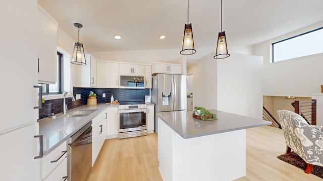 kitchen featuring decorative backsplash, appliances with stainless steel finishes, white cabinetry, and sink