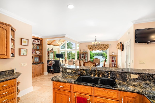 kitchen with crown molding, open shelves, brown cabinetry, a sink, and a chandelier