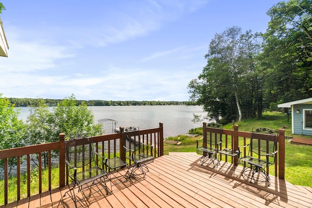 deck featuring a water view and a lawn