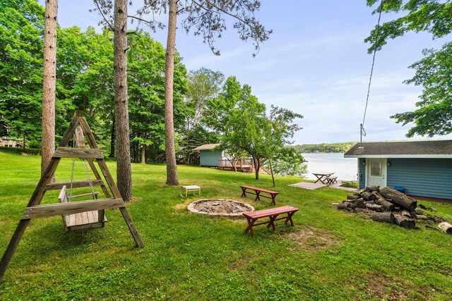 view of yard featuring a water view and a fire pit