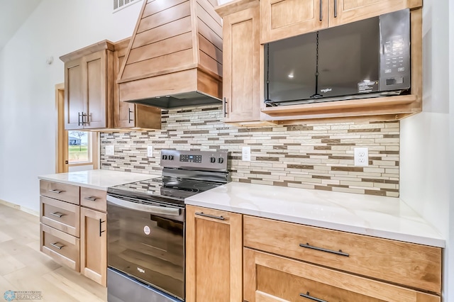 215 Emma Ct, Mapleton, ND 58059 - kitchen with stainless steel range with electric cooktop, custom range hood, black microwave, and tasteful backsplash