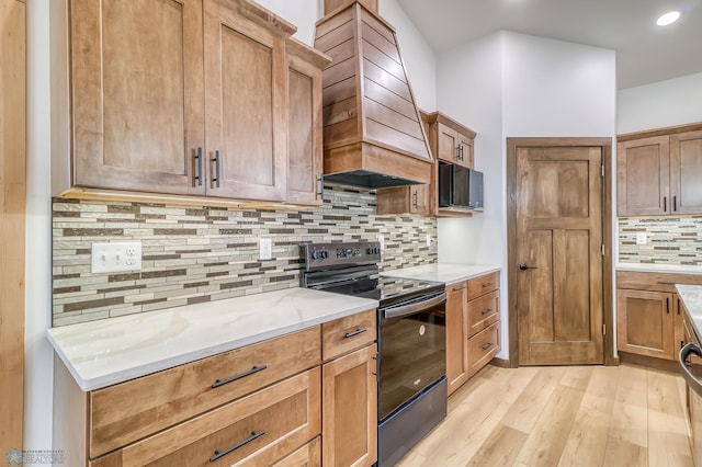 215 Emma Ct, Mapleton, ND 58059 - kitchen with electric range, tasteful backsplash, light wood finished floors, custom exhaust hood, and light stone counters