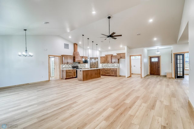 kitchen with a center island, hanging light fixtures, tasteful backsplash, light hardwood / wood-style floors, and custom range hood