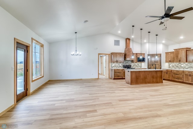 kitchen featuring decorative backsplash, a kitchen island, decorative light fixtures, and light wood-type flooring