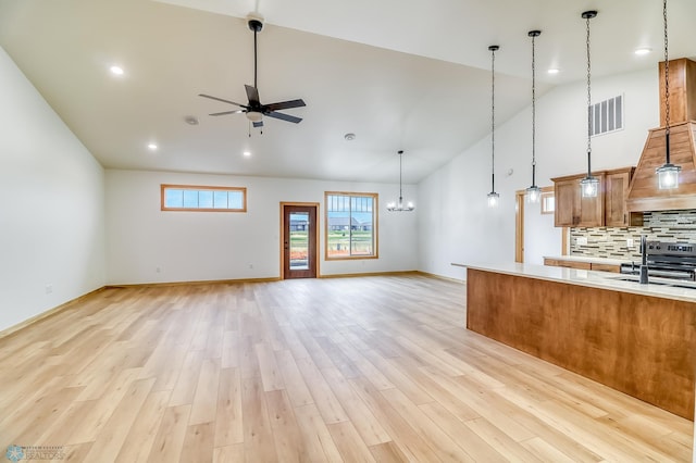 215 Emma Ct, Mapleton, ND 58059 - unfurnished living room featuring high vaulted ceiling, a ceiling fan, a sink, baseboards, and light wood-style flooring