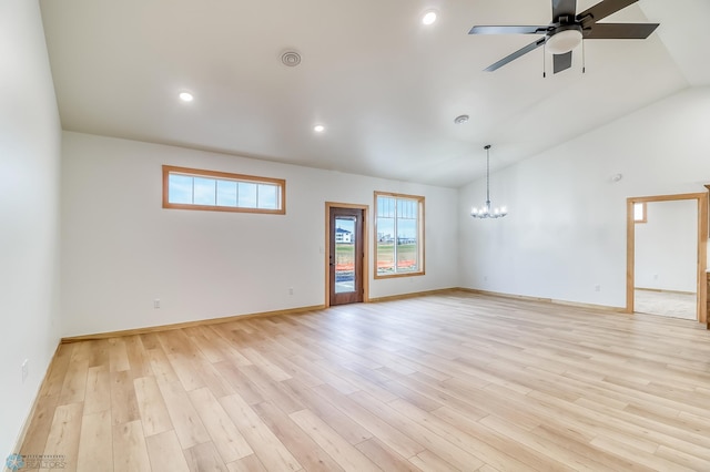 spare room with light hardwood / wood-style flooring, ceiling fan with notable chandelier, and vaulted ceiling