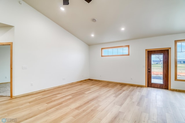 unfurnished room with lofted ceiling, ceiling fan, and light wood-type flooring