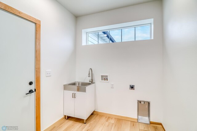 laundry room featuring sink, a healthy amount of sunlight, light wood-type flooring, and hookup for an electric dryer