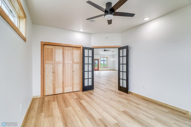 unfurnished bedroom featuring a closet, light wood-type flooring, and french doors