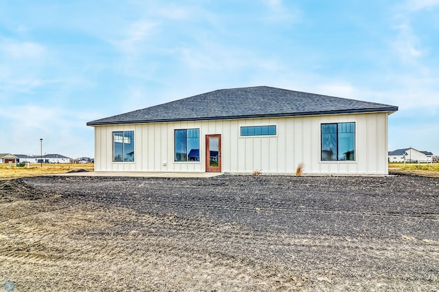 215 Emma Ct, Mapleton, ND 58059 - back of property with a shingled roof, board and batten siding, and a patio area
