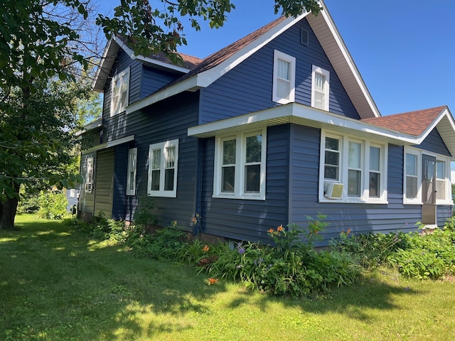 view of side of home with a lawn