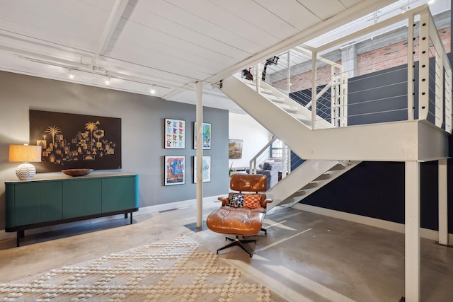 interior space featuring rail lighting and concrete floors