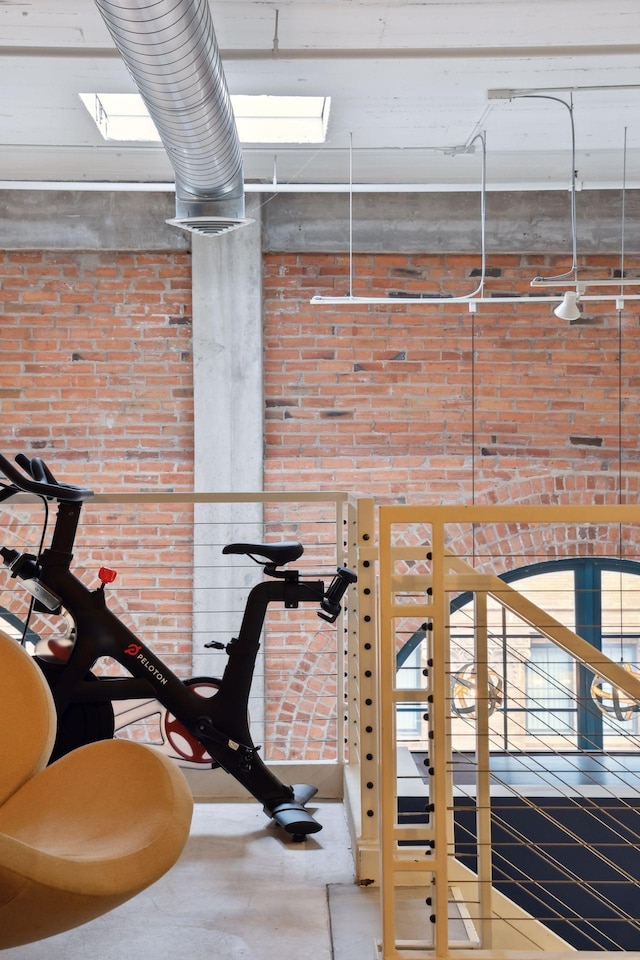 exercise room featuring brick wall