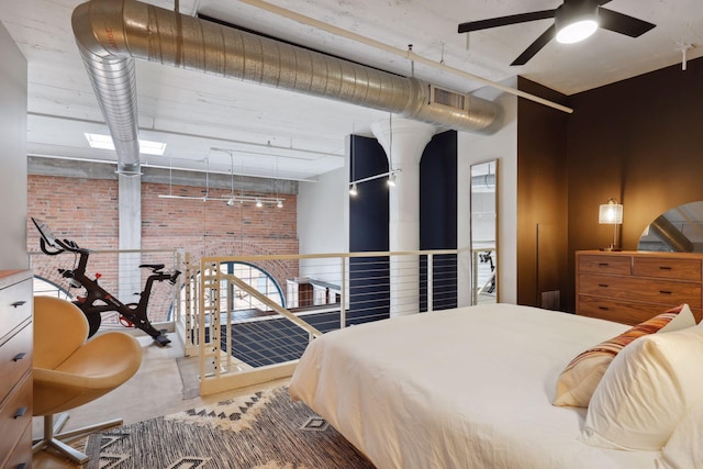 bedroom featuring track lighting and brick wall