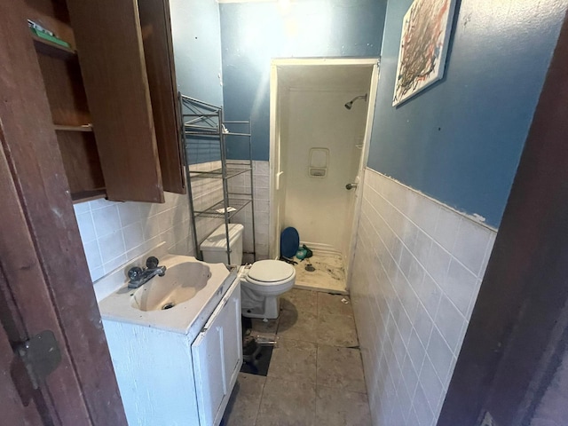 bathroom with tasteful backsplash, tile walls, toilet, tile patterned floors, and vanity