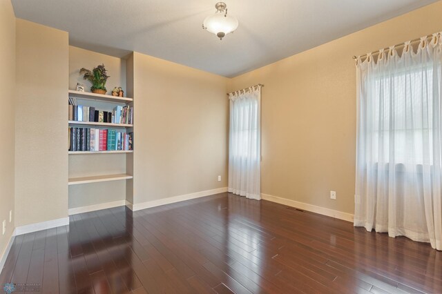 empty room with dark hardwood / wood-style flooring