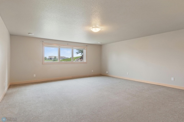 unfurnished room featuring light colored carpet and a textured ceiling