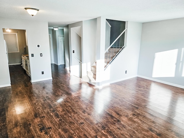 spare room featuring a textured ceiling and dark wood-type flooring