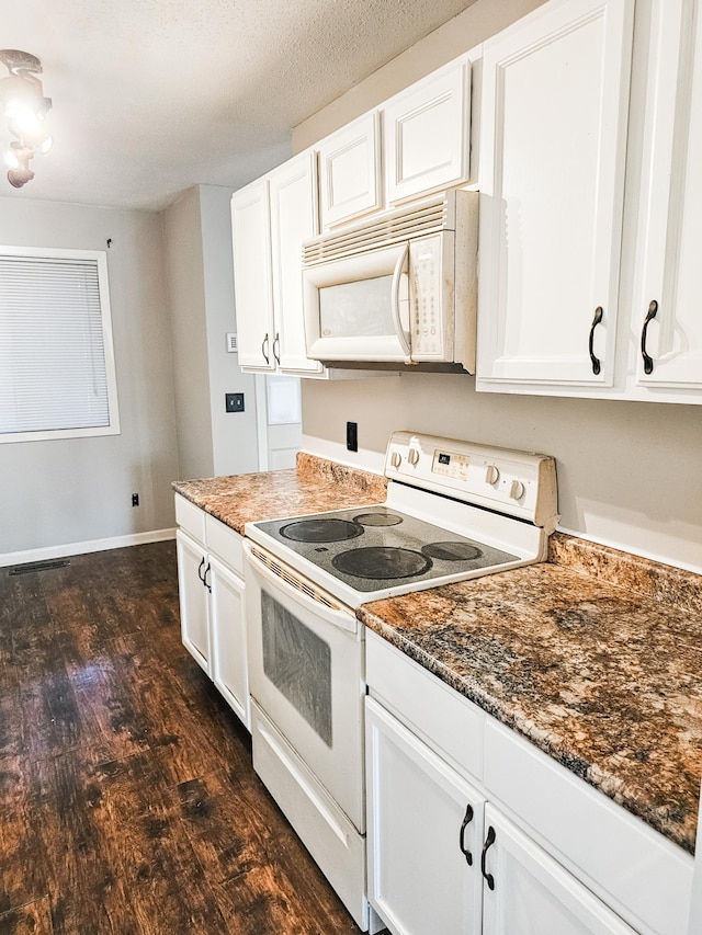 kitchen with white cabinetry, dark hardwood / wood-style flooring, dark stone counters, a textured ceiling, and white appliances