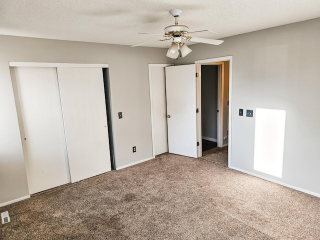 unfurnished bedroom featuring ceiling fan, carpet, and a textured ceiling