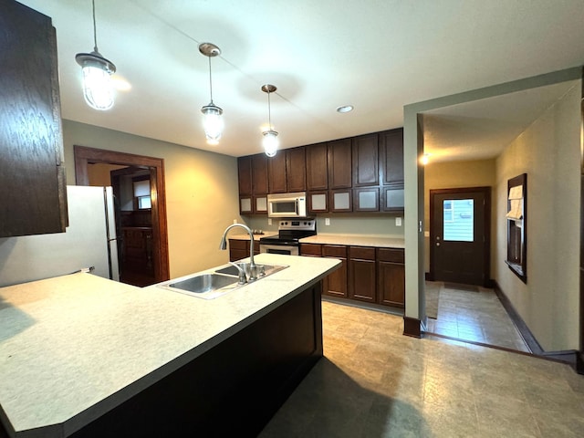 kitchen with dark brown cabinetry, white appliances, hanging light fixtures, and sink