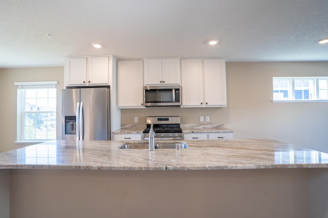 kitchen featuring white cabinets, stainless steel appliances, and a large island