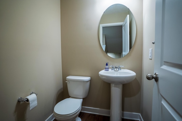 bathroom with hardwood / wood-style floors, toilet, and sink