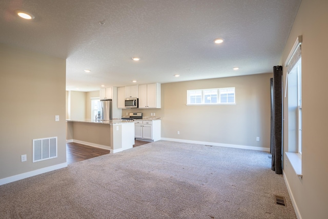 unfurnished living room with carpet and a textured ceiling