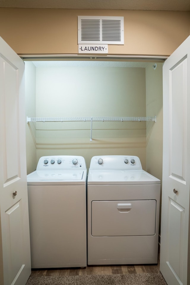 laundry room featuring hardwood / wood-style floors and washer and dryer