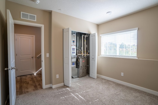 unfurnished bedroom featuring a textured ceiling and carpet floors