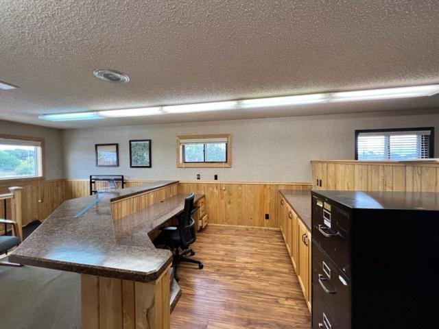 home office with a textured ceiling and light wood-type flooring