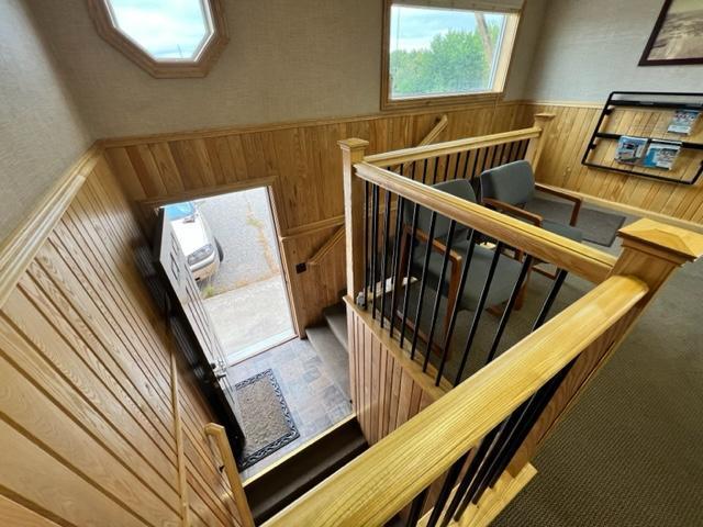 stairway featuring wood walls