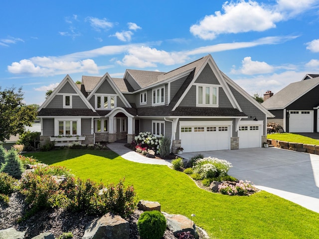 view of front of property with concrete driveway, a garage, a front yard, and stone siding