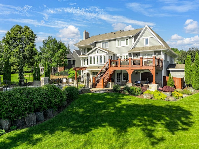 rear view of property with fence, a wooden deck, a chimney, stairs, and a lawn