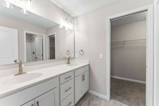 bathroom featuring walk in shower, hardwood / wood-style flooring, and vanity