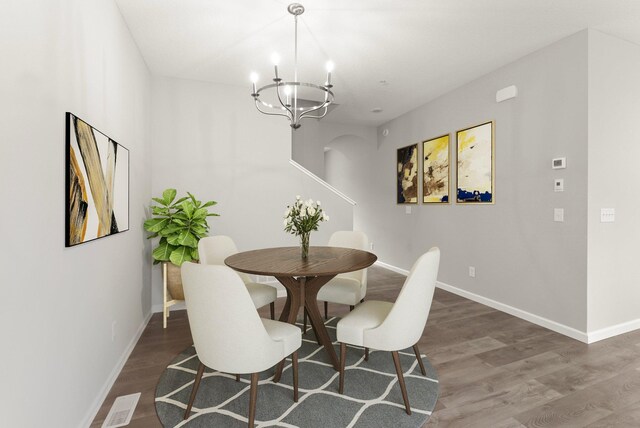 dining room featuring dark wood-type flooring and an inviting chandelier