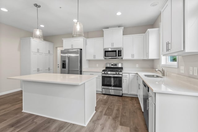 kitchen featuring a kitchen island, wood-type flooring, sink, and appliances with stainless steel finishes