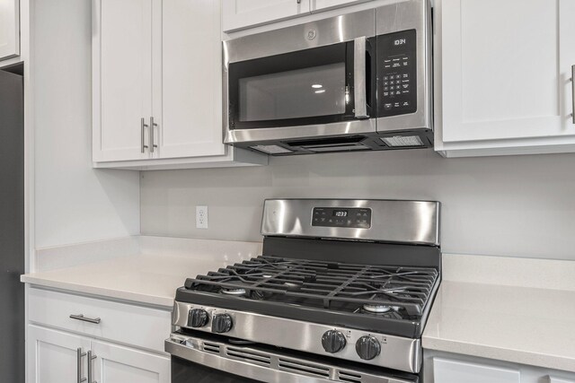 kitchen featuring stainless steel appliances and white cabinetry