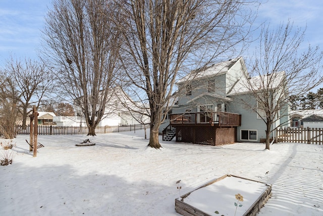 snowy yard with stairway, fence, and a wooden deck