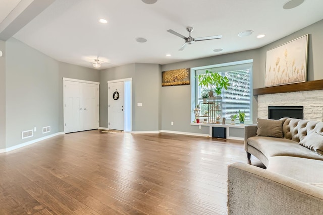 living room with a fireplace, ceiling fan, and hardwood / wood-style floors