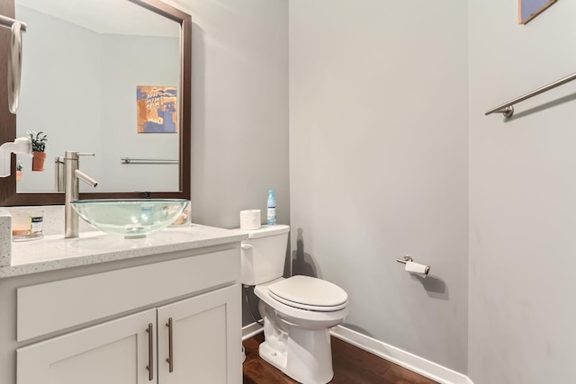 bathroom with toilet, hardwood / wood-style floors, and vanity