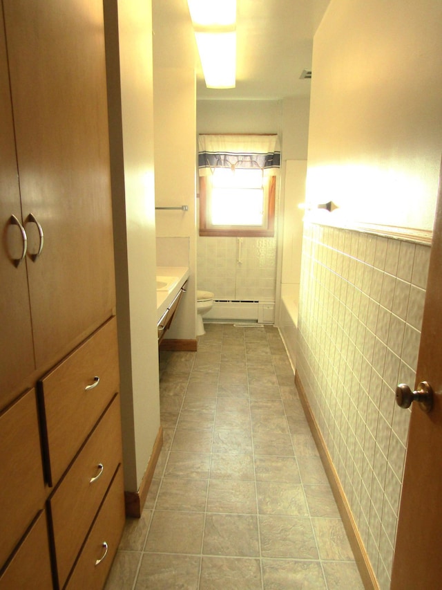 bathroom with tile patterned floors, toilet, vanity, and a baseboard radiator