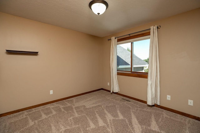 carpeted empty room featuring a textured ceiling