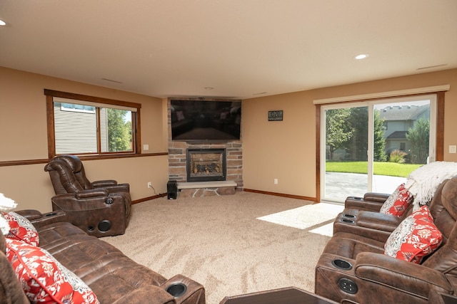 carpeted living room featuring a wealth of natural light and a stone fireplace