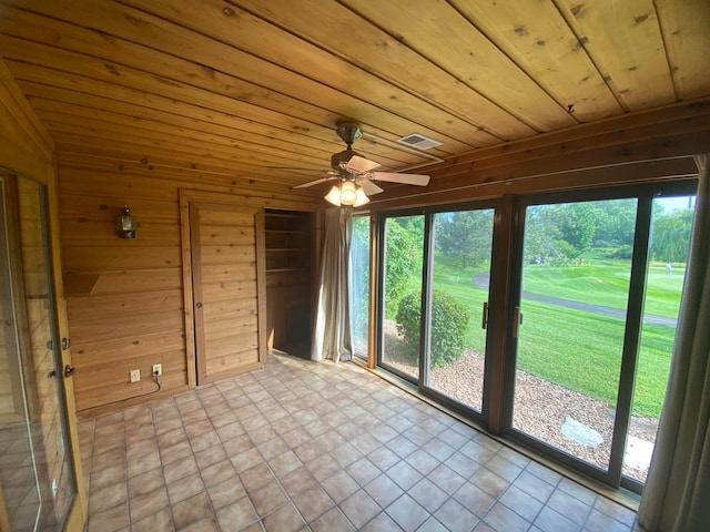 interior space featuring a wealth of natural light, wooden ceiling, and wooden walls