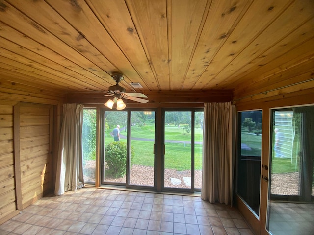 interior space with wood ceiling, wood walls, and ceiling fan