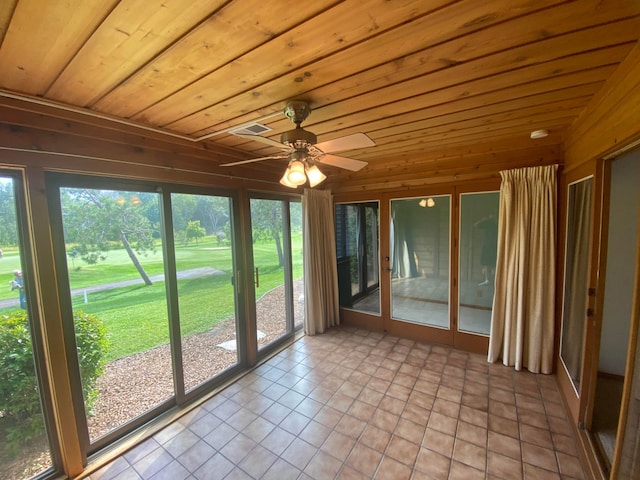 unfurnished sunroom featuring wooden ceiling, ceiling fan, and a wealth of natural light