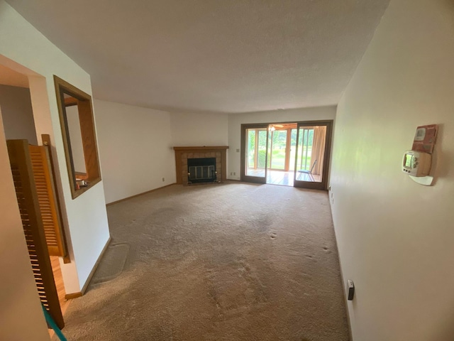 unfurnished living room with carpet floors and a fireplace