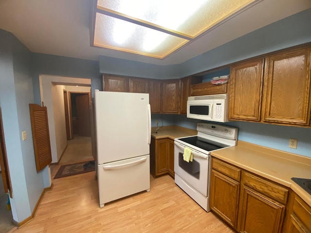 kitchen with light hardwood / wood-style flooring and white appliances